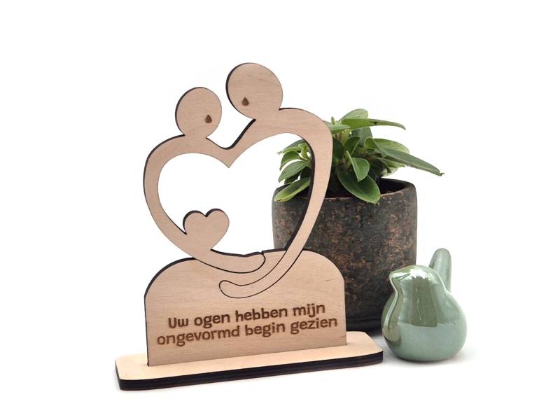 Houten item ter herinnering aan een stilgeboren kind of miskraam. Ouders die een hart omarmen als symbool van liefde en rouw.