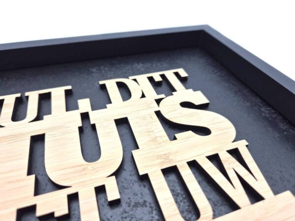 Close‑up van houten letters op zwarte achtergrond met de tekst “Vul dit huis met Uw glorie” als moderne christelijke wanddecoratie.