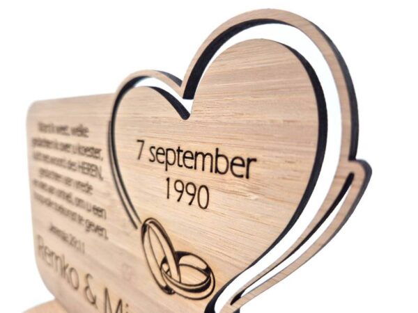 Huwelijkscadeau met hart en ringen. Namen bruidspaar, trouwdatum en persoonlijke tekst of trouwtekst. Detailfoto