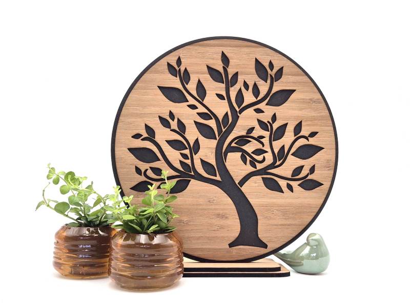 Ronde afbeelding van levensboom uitgesneden in hout en op achtergrond gemonteerd.