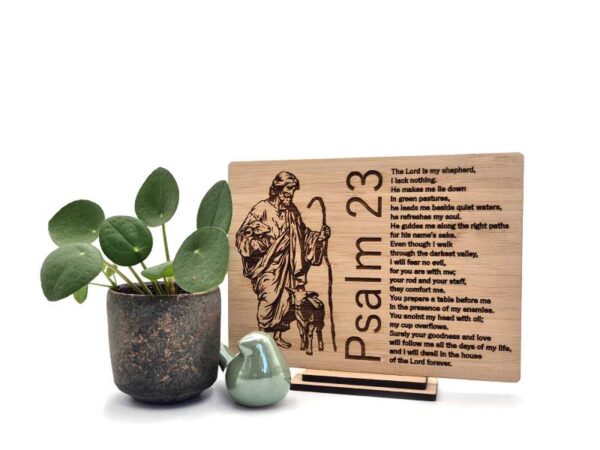 Houten Psalm 23 decoratie met herder en lam en de tekst “The Lord is my shepherd” in het Engels, naast plant en keramieken vogeltje.