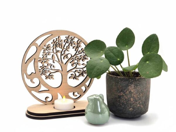 Houten waxinelichthouder met levensboom, gecombineerd met plant en keramieken vogeltje als sfeervolle decoratie.