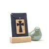 Houten dogtag met uitgesneden kruis aan een zwart leren ketting.