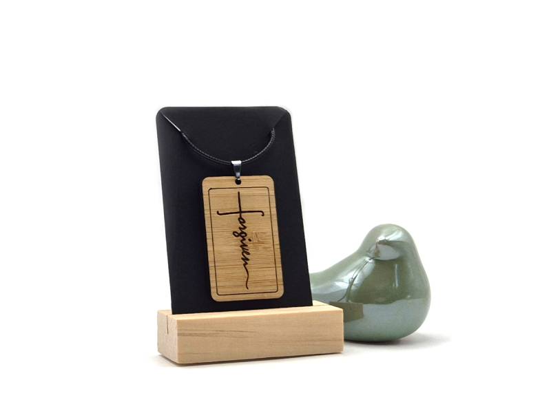 Houten dogtag van 5 x 3 cm met het woord Forgiven erop gegraveerd.