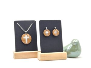 Set van houten ronde sieraden met wit kruisje in het midden. Handgemaakt van bamboe en afwerkt met een glaslaagje van epoxy. De oorstekers en ketting zijn gemaakt van roestvrijstaal
