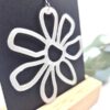 Handgemaakte oorbellen in bloemvorm, gemaakt van witte resin met een glitter erin.